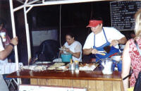 huaraches preparing mexican food on a street stall